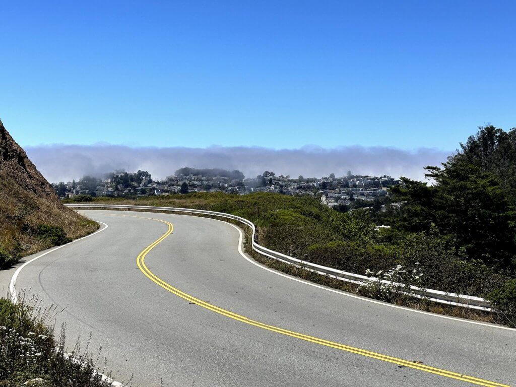 Route descendant de Twin Peaks avec brume sur l'entrée de la baie de San Francisco